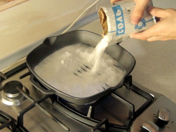 Соль сыпят на чугунную сковороду-гриль